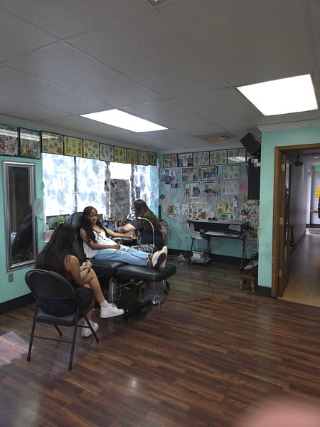 Evolution Tattoo artist tattooing a client at their station