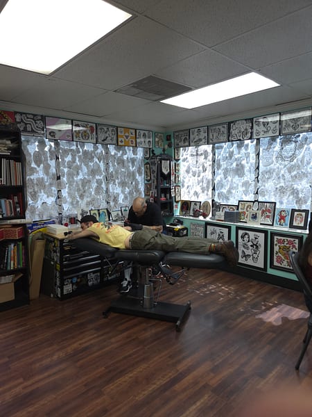 Artist at work in a private tattoo station